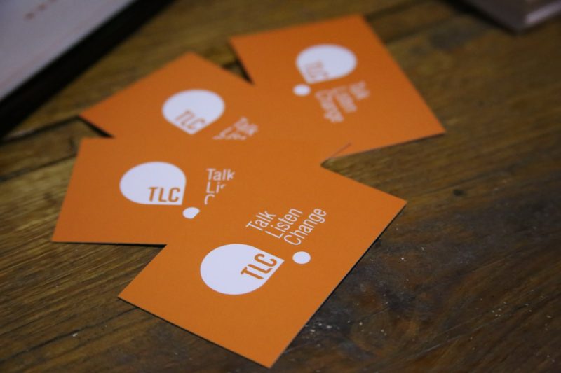 four TLC: Talk, Listen, Change business cards on a table