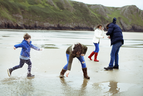 a man and women on a beach with a teenage girl and a young boy