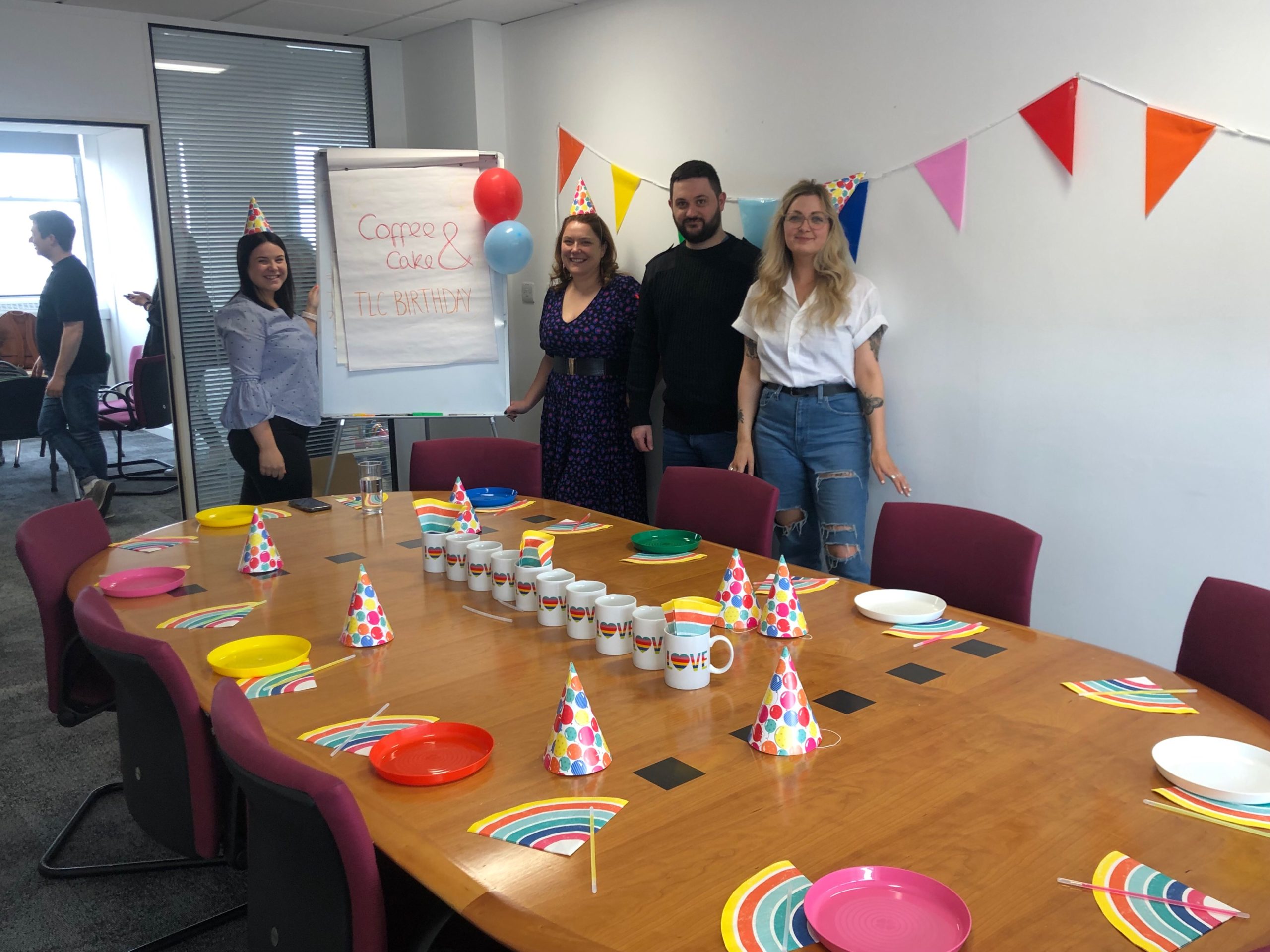 four o=people posing with birthday decorations around them