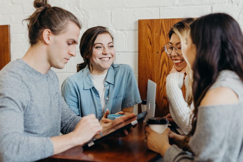 a group of women in a coffee shop talking happily