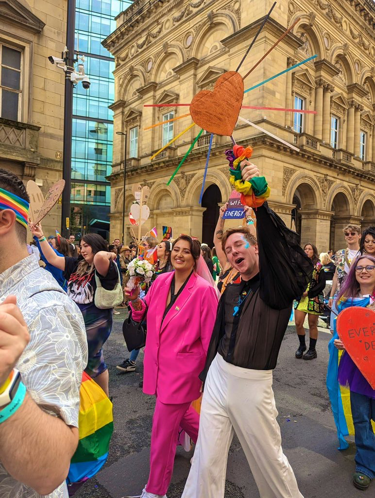 a man and woman marching in Manchester pride parade