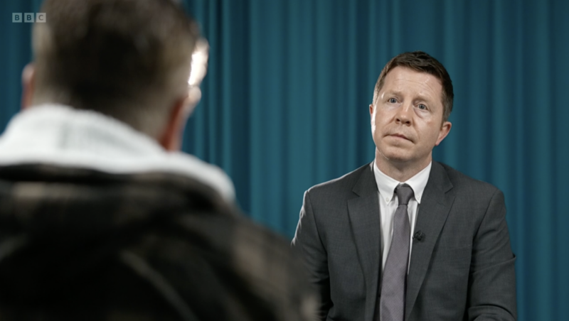 silhouette of ex-service user facing an interviewing journalist.