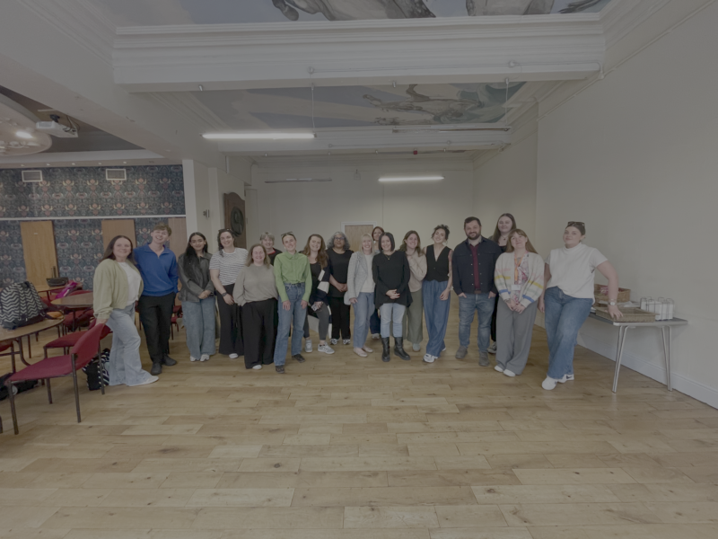 A landscape picture of a group of TLC staff members after a training session. 18 people featured