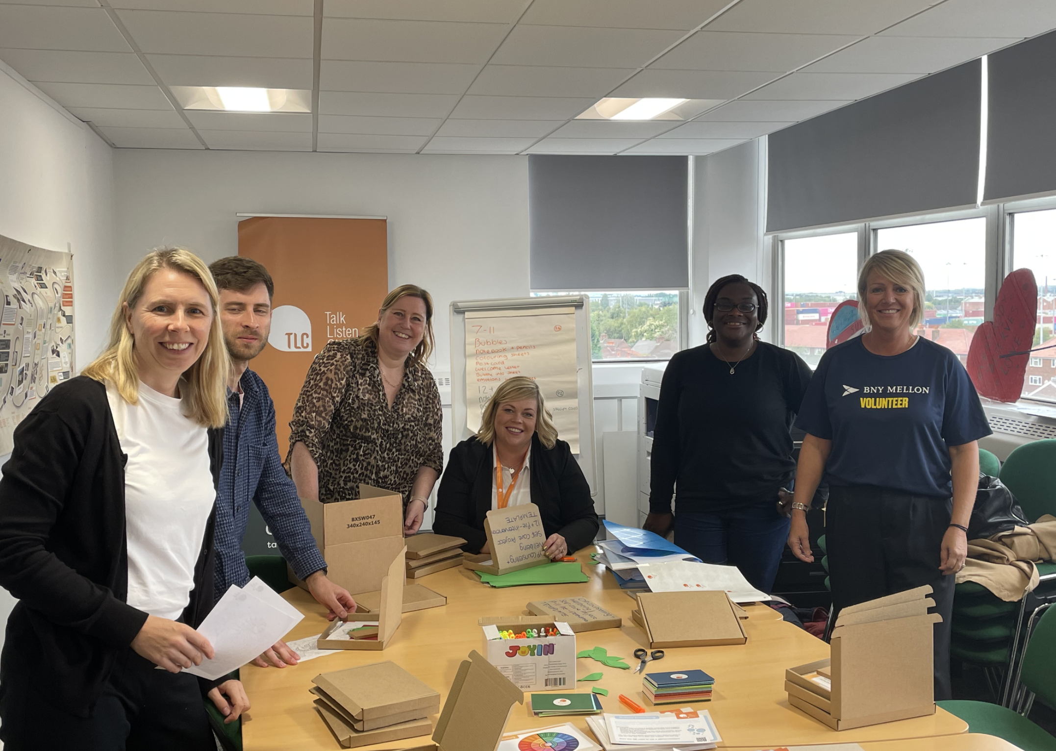 group of BNY Mellon volunteers in the TLC head office making wellbeing packs for children