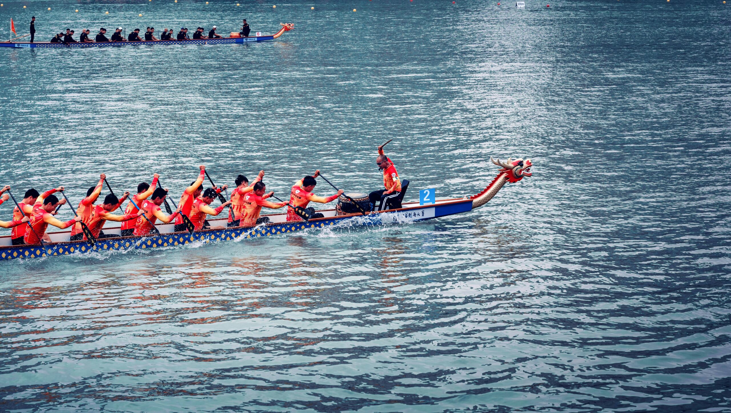 Team of rowers on the water, in a boat with a dragon head